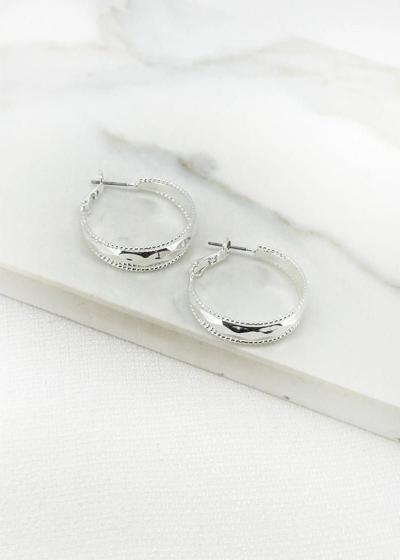 Silver hoop earring with faceted detail